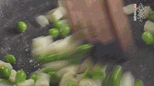 鍋中油7成熱時(shí)，入青豆、筍丁翻炒，然后加糯米飯加鹽均勻翻炒。