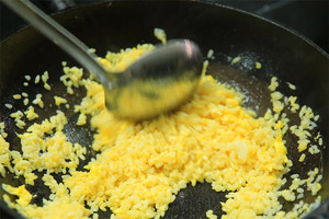 大火加熱炒鍋，再入油，燒到四至五成熱時倒入雞蛋液，在未凝結之前，加米飯煸炒，不停翻炒并用鍋鏟將成塊的米飯碾開、撥散。