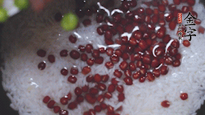 將炒好的食材和大米、紅豆一起放進(jìn)電飯鍋煮。