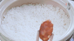 煮開后轉(zhuǎn)小火，當(dāng)米飯出現(xiàn)小孔時(shí)，鋪上金字麻辣香腸。