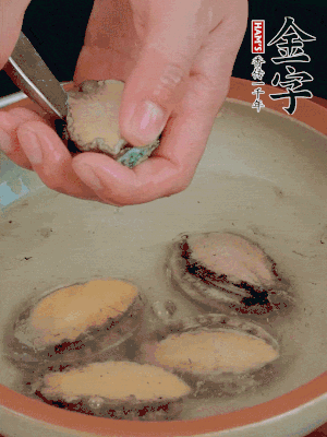 鮑魚加鹽、清水浸泡，用勺子挖出鮑魚肉。