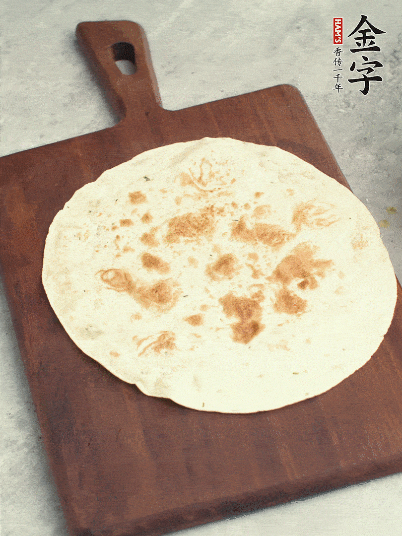 食材依次鋪在卷餅皮上，卷起來。