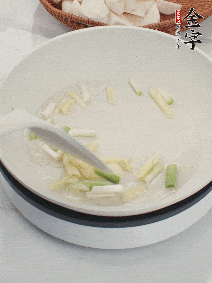 鍋中油五成熱，下蔥白、姜片爆香。