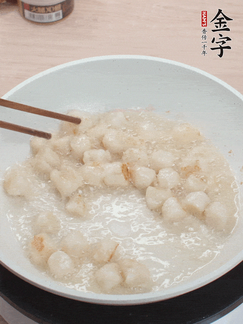 油溫4成熱，鮮貝蘸干淀粉下鍋煎，一面微黃后翻面。