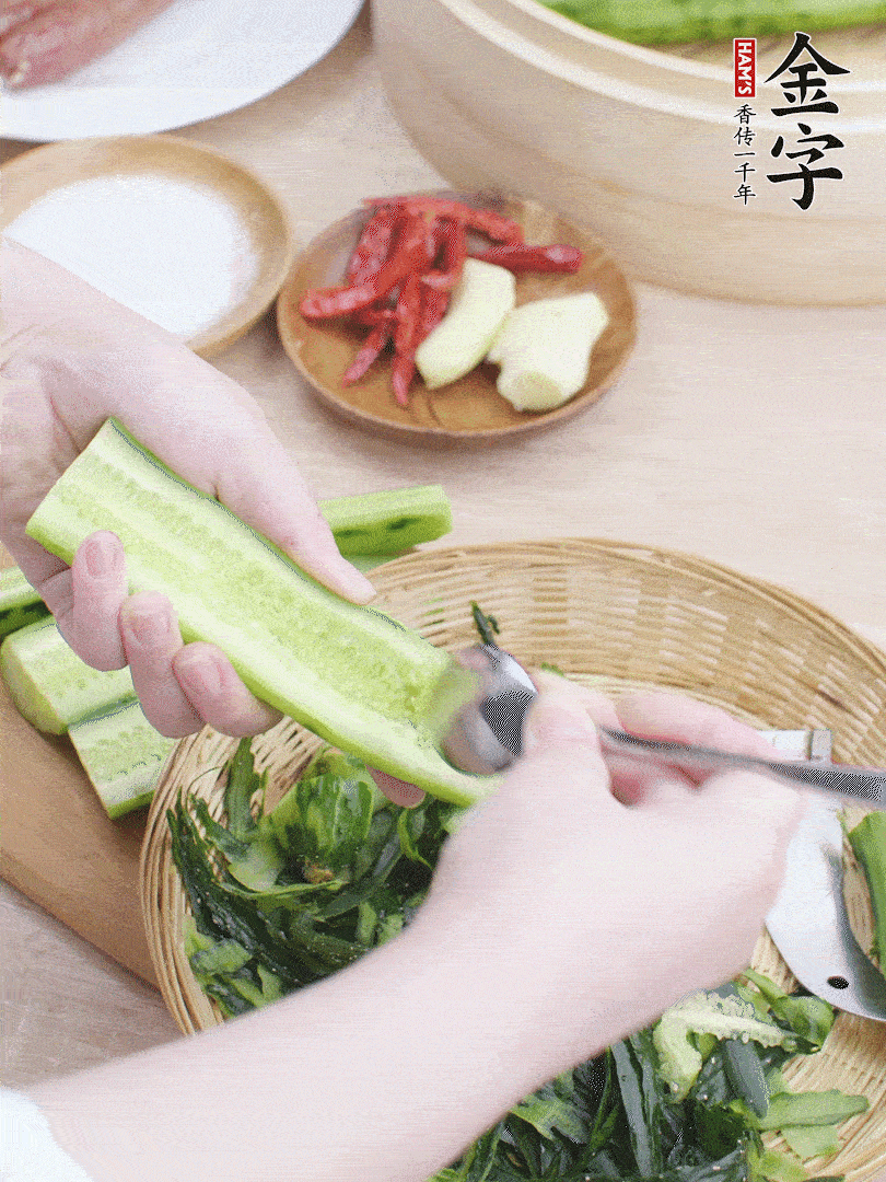 黃瓜削皮，對半切開，勺子挖去內瓤，斜刀切片。青蒜斜刀切段。