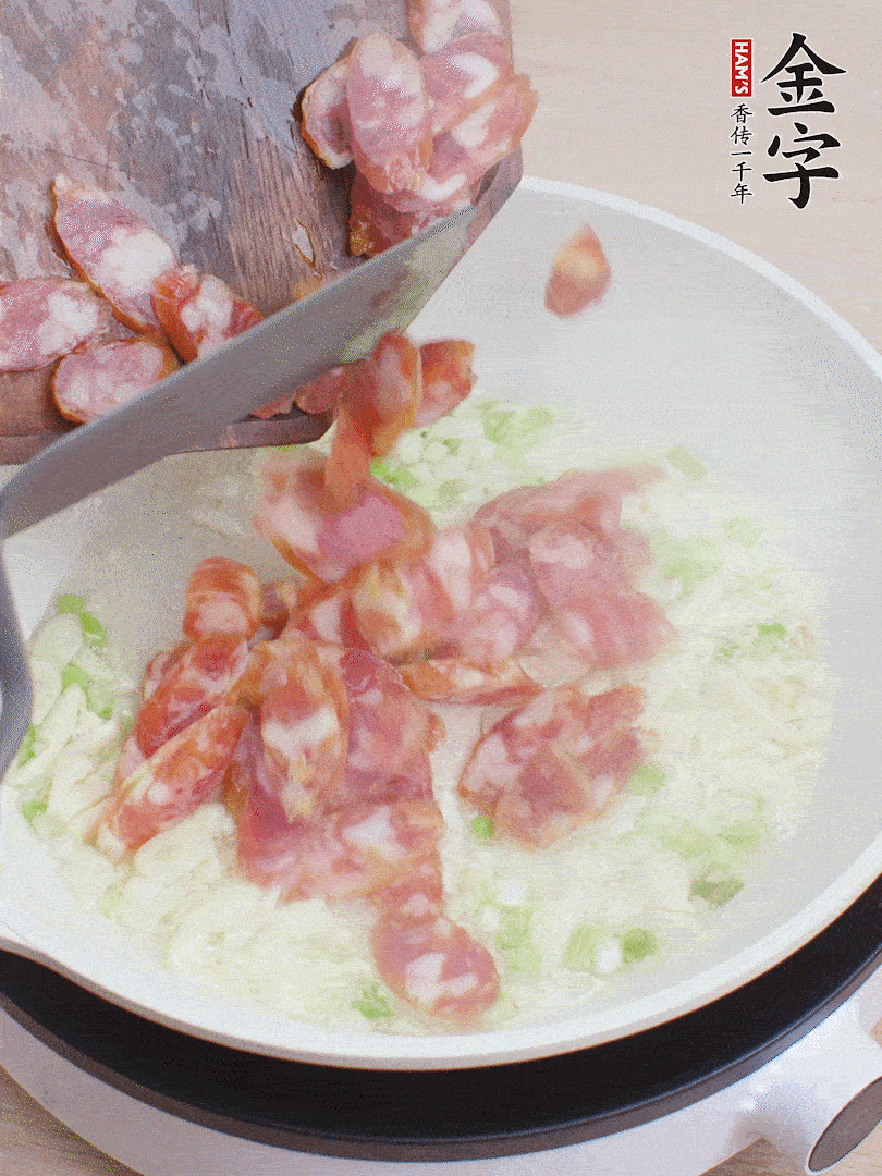 油5成熱，蒜末、蔥白爆香，下香腸炒出香味。