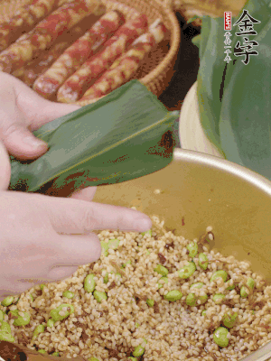 粽葉往下折，完全蓋住，兩側(cè)捏緊。
