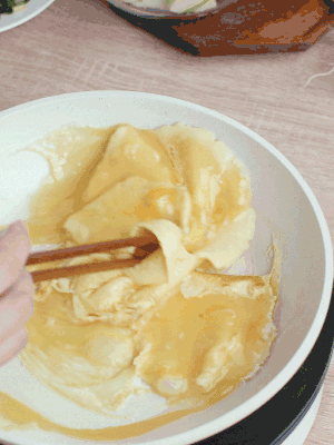 油6成熱時，下雞蛋液，邊緣凝固時翻拌成塊狀。