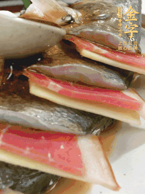 魚肚中塞蔥結(jié)、火腿片，魚身上碼放姜片、火腿片，倒入混合的料汁。