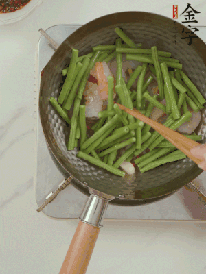 下掰好的缸豆段翻炒，略燜煮。