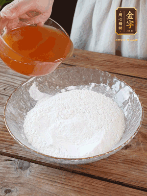 轉(zhuǎn)化糖漿、枧水、花生油攪拌均勻，加入面粉混合，醒發(fā)2小時(shí)。捏成23g一個(gè)的小球