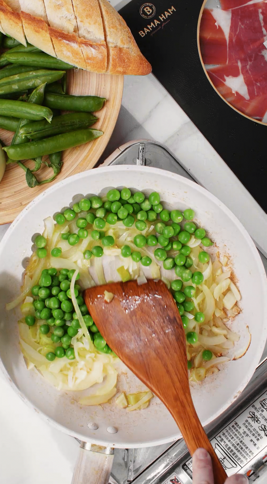 鍋中放入黃油融化，加入洋蔥絲、大蔥蔥白絲、蒜末翻炒變軟出香味。加入剛剛汆燙冰鎮(zhèn)后的豌豆，取出一點點待會擺盤裝飾用。加一點鹽 (和黑胡椒) 調味。